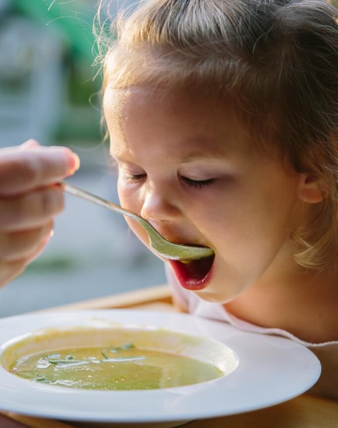 Nahaufnahme Mädchen wird mit Suppe gefüttert