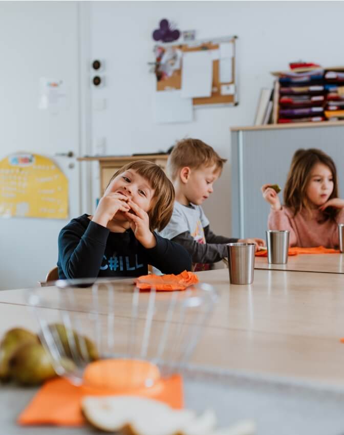 Kinder in Kindertagesstätte beim Essen
